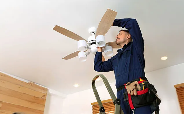 Licensed electrician fixing a ceiling fan mounting bracket to a joist