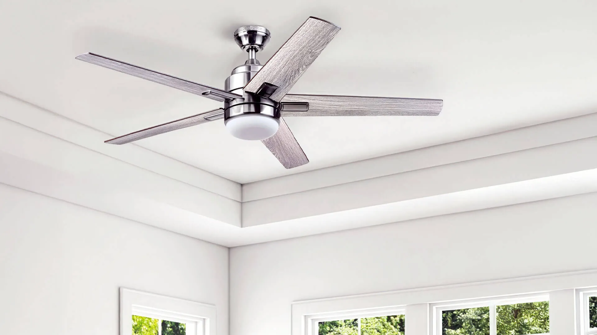 Electrician fitting a ceiling fan in a Brisbane living room