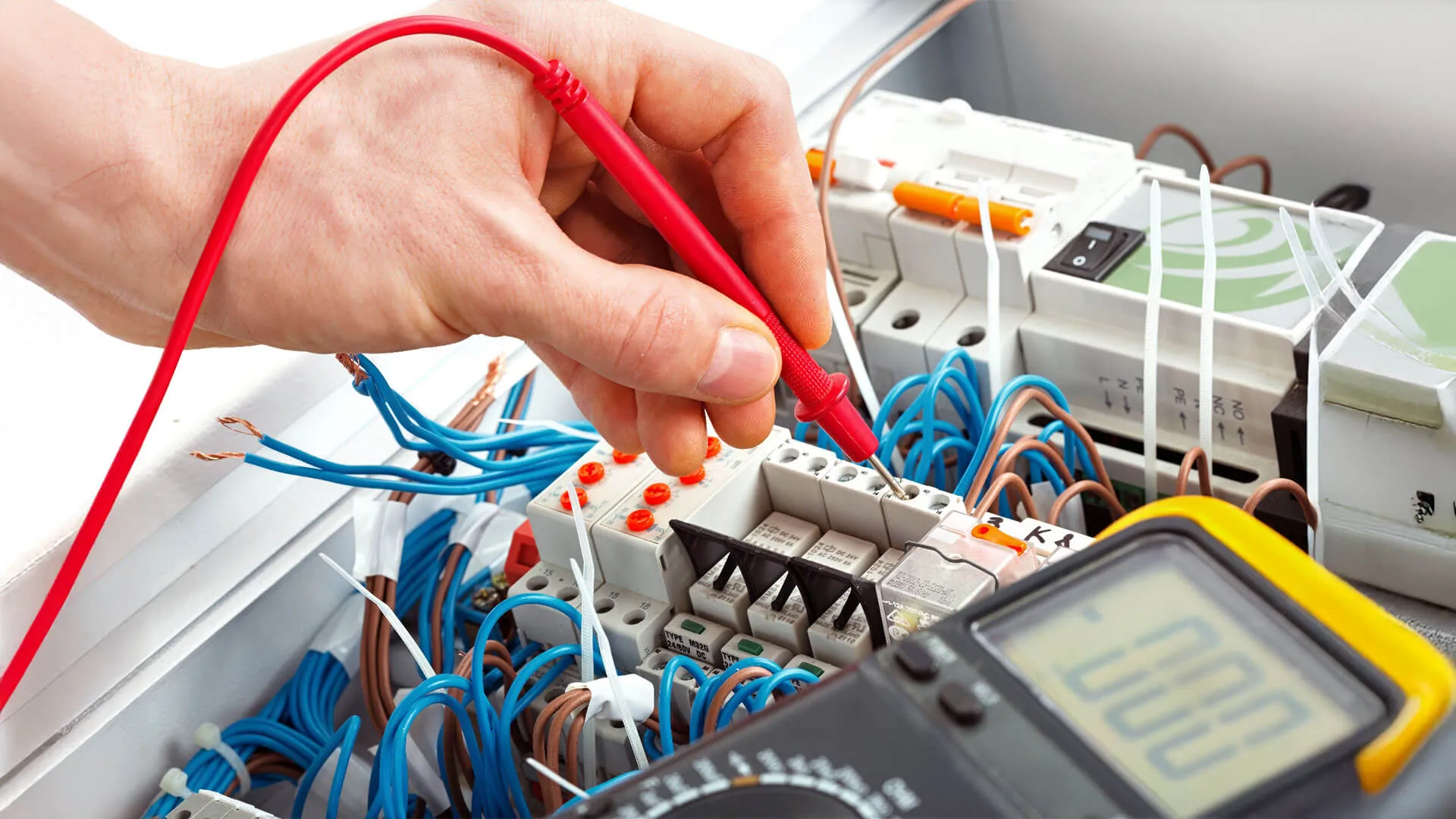 Electrician inspecting an older ceramic fuse switchboard in Brisbane